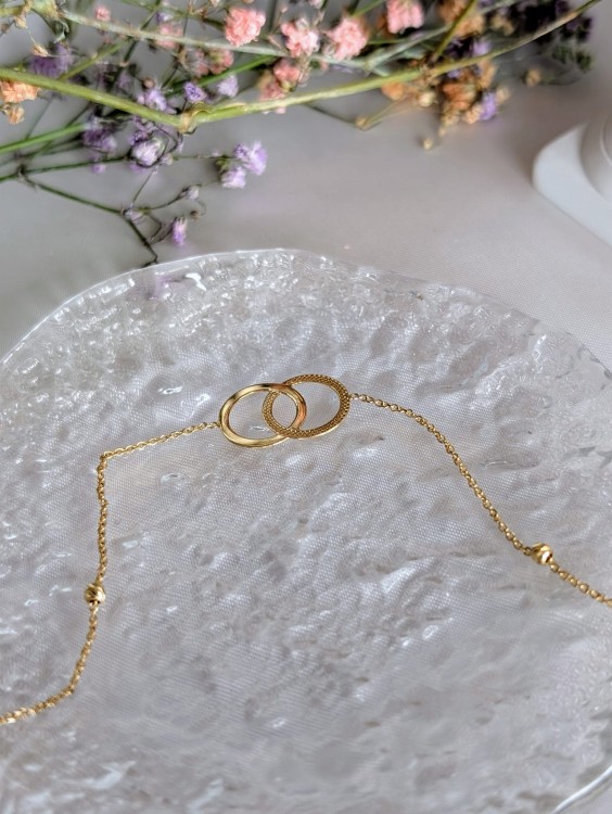 Złota błyszcząca bransoletka z połączonymi obrączkami i kuleczkami diamentowanymi. Długość 17-19 cm, splot ankier, zapięcie sprężynowe Federing. Średnica elementu 11.4 mm. Idealna złota biżuteria na prezent.