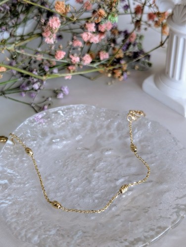 Złota błyszcząca bransoletka z diamentowanymi baryłkami i splotem ankier. Długość 16-19 cm, średnica 2,9 mm, zapięcie karabińczyk. Elegancka złota biżuteria.